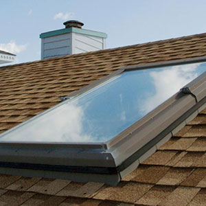 Close up of a skylight on a brown shingle residential roof